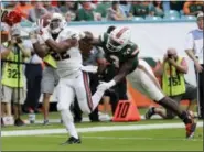  ?? LYNNE SLADKY — THE ASSOCIATED PRESS ?? Virginia running back Daniel Hamm (22) catches a pass that he ran in for a touchdown as Miami defensive back Dee Delaney (3) defends during the second half of an NCAA college football game, Saturday in Miami Gardens, Fla. Miami won 44-28.