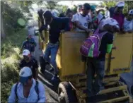  ?? AP PHOTO/RODRIGO ABD ?? Central American migrants traveling with a caravan to the U.S. make their way to Pijijiapan, Mexico, on Thursday. The sprawling caravan of migrants hoping to make their way to the United States set off again, forming a column more than a mile long as the group trekked out of the town of Mapastepec in southern Mexico before dawn.