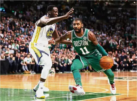  ??  ?? Look Ma, no mask: Kyrie Irving (right) of the Boston Celtics driving against Draymond Green of the Golden State Warriors during the fourth quarter of their NBA game in Boston on Thursday. — AFP