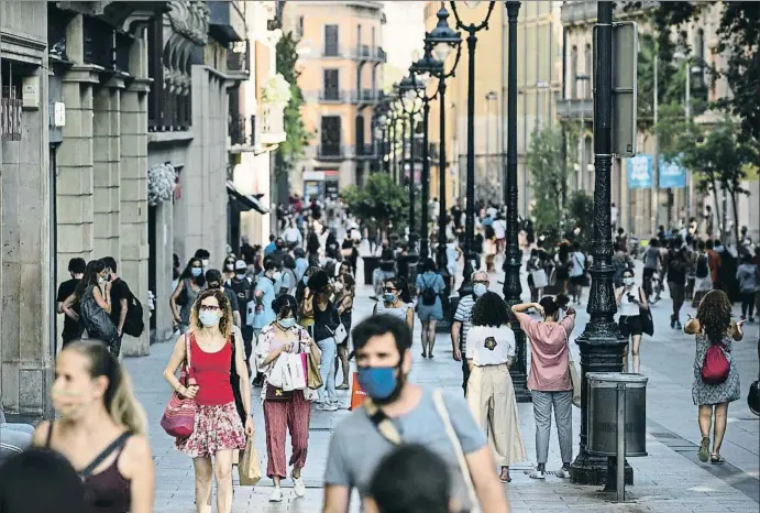  ?? CESC MAYMO / GETTY ?? Esta imagen de gente paseando y de compras por portal de l’àngel, en Barcelona, va a continuar siendo habitual