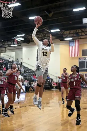  ?? Staff photo by Hunt Mercier ?? ■ Lady Hawks’ Miaya Ware jumps up to shoot the ball into the Lady Leopards’ basket at Hawks Gym on Friday in Texarkana, Texas.