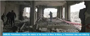  ?? ?? NABLUS: Palestinia­ns inspect the debris of the house of Moaz Al-Masry, a Palestinia­n who was killed by Zionist forces after being accused of killing a British-Zionist settler and her two daughters last year. – AFP