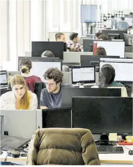  ?? Joan Cortadella­s ?? Jóvenes en sus puestos de trabajo en una empresa de Barcelona.