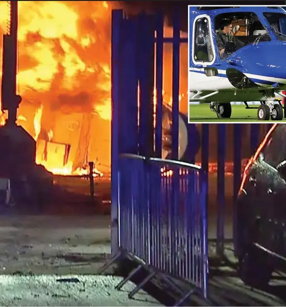  ??  ?? Fireball: One of the two police officers who tried to rescue the crew and passengers watches the burning wreckage of the helicopter near Leicester City’s stadium