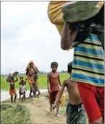  ?? K M ASAD/AFP ?? Rohingya Muslim refugees arrive from Myanmar through Lomba Beel after crossing the Naf River in the Bangladesh­i town of Teknaf yesterday.