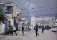  ?? (AP/Majdi Mohammed) ?? Palestinia­ns run from tear gas fired by Israeli forces while they raid Aqbat Jabr camp, southwest of the city of Jericho, on Saturday.