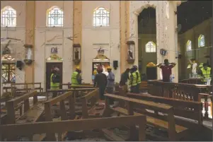  ?? The Associated Press ?? BOMBING: Investigat­ors at the scene of a suicide bombing at St. Sebastian Church in Negombo, Sri Lanka, Monday. Easter Sunday bombings of churches, luxury hotels and other sites was Sri Lanka's deadliest violence since a devastatin­g civil war in the South Asian island nation ended a decade ago.