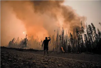  ?? CP FILE PHOTO ?? Verne Tom photograph­s a wildfire burning approximat­ely 20 kilometres southwest of Fort St. James on Aug. 15, 2018.