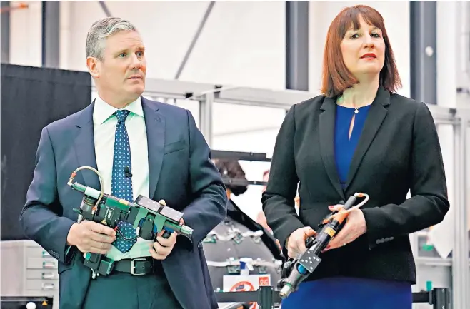  ?? ?? Sir Keir Starmer and Rachel Reeves, the shadow chancellor, with rivet guns used to make aircraft wings during their visit to Here East, an innovation and technology campus at Queen Elizabeth Olympic Park in east London