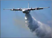  ?? RURAL FIRE SERVICE VIA AP ?? A C-130 Hercules plane called “Thor” drops water during a flight in Australia. Three American crew members were killed Thursday when a C-130 aerial water tanker crashed while battling wildfires in southeaste­rn Australia.