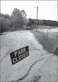  ?? NWA Democrat-Gazette/SPENCER TIREY ?? The Lake Bella Vista’s trail has been closed since heavy ran flooded the lake and piled wood and debris on the dam earlier this month.