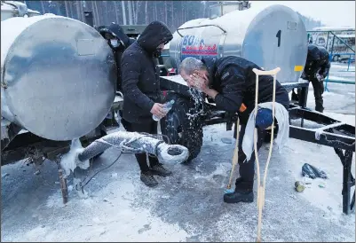  ?? (AP/Pavel Golovkin) ?? A migrant washes his head with cold water Thursday at the Bruzgi checkpoint logistics center at the Belarus-Poland border near Grodno, Belarus.