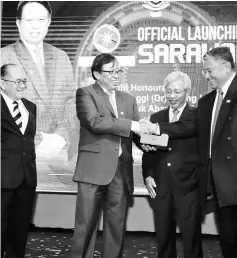  ??  ?? Morshidi (right) presents a memento to Abang Johari. Also seen are Uggah (left) and Masing.