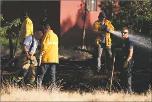  ??  ?? Taos fire crews work to put out a small fire that spread quickly off of Gusdorf Road Tuesday (June 12).