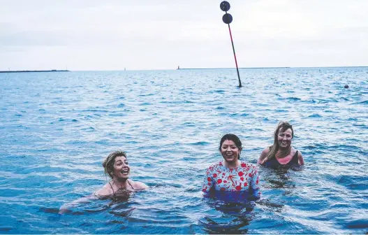  ?? PHOTOS: JAMES FORDE/THE WASHINGTON POST ?? Gillian Skully, left, Mia Skully and Patricia Penny of the Dollymount Dames take a dip outside Clontarf Yacht & Boat Club in County Dublin.