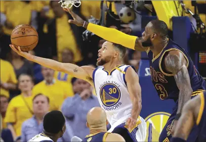  ?? Associated Press photos ?? Golden State Warriors guard Stephen Curry shoots against Cleveland Cavaliers forward LeBron James during Game 1 of the NBA Finals on Thursday night in Oakland. The Warriors will look to take a 2-0 series lead when the teams meet again tonight for Game 2.