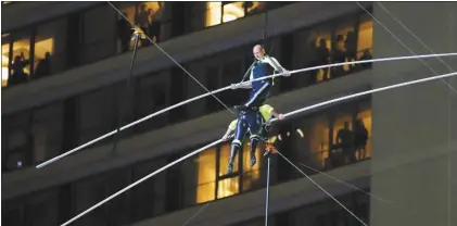  ?? AP photo ?? Aerialist Nik Wallenda (top) steps over his sister Lijana Wallenda as they walk on a high wire above Times Square on Sunday in New York.