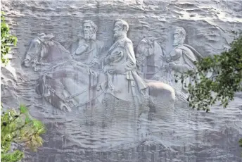  ?? JOHN BAZEMORE, AP ?? A carving depicts Confederat­es Stonewall Jackson, Robert E. Lee and Jefferson Davis in Stone Mountain, Ga. The memorial to three Southern Civil War leaders offends some people.