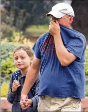  ?? GEOFF CRIMMINS / THE MOSCOW-PULLMAN DAILY NEWS ?? Chris Karn covers his face to filter out smoke from wildfires while walking daughter Chloe to school Tuesday in Moscow, Idaho.