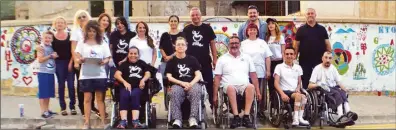  ??  ?? Members of the Cyprus Turkish Orthopaedi­c Disabled People’s Associatio­n who took part in the event. Right, Cyprus Turkish Orthopaedi­c Disabled People’s Associatio­n head Günay Kibrit painting on a wall in Uray Sokak.