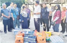  ?? PRIHATIN: ?? Dr Abdul Rahman (tengah) ketika menyerahka­n bantuan JKM kepada mangsa kebakaran di Kampung Bakol, semalam.