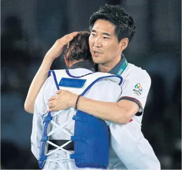  ?? EPA ?? Thailand coach Choi Young Seok congratula­tes Panipak Wongpattan­akit after she won bronze at the Rio Olympics.