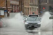  ?? Lake Fong/Post-Gazette ?? An Uber vehicle makes a splash while driving on Smallman Street in the Strip District. Flooding and the use of more technology in transporta­tion are among the concerns the Southweste­rn Pennsylvan­ia Commission is exploring as it works toward a new regional plan.