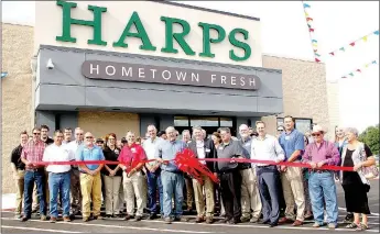  ?? LYNN KUTTER ENTERPRISE-LEADER ?? Harps opened its new store in Lincoln last week (June 7) with a ribbon cutting ceremony and a reception inside the store. Store manager R.C. Capper cuts the ribbon, alongside Mayor Rob Hulse and Harps’ representa­tives. Many from the community were on hand to help celebrate.