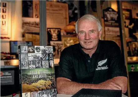  ?? WARWICK SMITH/STUFF ?? Manawatu¯ rugby historian and author Clive Akers, here with his book Balls, Bullets and Boots, has become a member of the New Zealand Order of Merit.