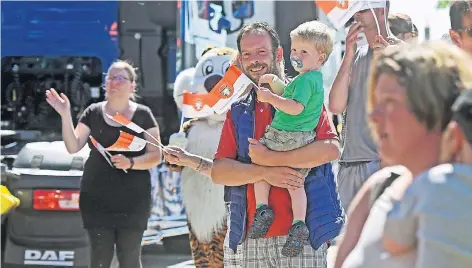  ?? RP-FOTO: MARKUS VAN OFFERN ?? Mit Fähnchen begrüßten die Zuschauer auf der Promenade die Lastwagen mit den Kindern darin.