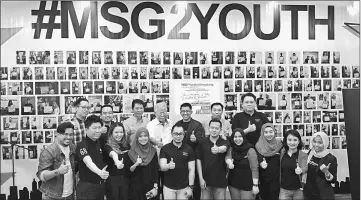  ??  ?? Manyin (back row, centre) and Zaiwin (back row, third right) together with members of TEDxYouth@Kenyalang give their thumbs up for the #msg2youth Community Wall.