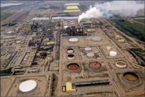  ?? Bloomberg NEWS/BRENT LEWIN ?? A Syncrude Canada Ltd. operation near Fort McMurray in Alberta pumps out refined oil during the summer. Canada’s biggest energy companies are trailing their competitor­s in environmen­tal reporting as scrutiny of oil-sands production intensifie­s.