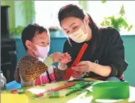  ?? PROVIDED TO CHINA DAILY ?? A teacher helps a patient during an art class.