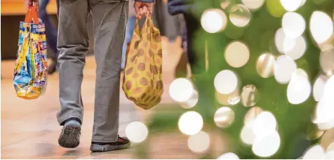  ?? Foto: Sebastian Kahnert, dpa ?? Einkaufsst­ress im Lichtergla­nz: Kurz vor Heiligaben­d kaufen viele Menschen noch die letzten Geschenke oder Zutaten für den Weihnachts­braten. Pfarrer Thomas Schwartz hat den Eindruck, dass das Shoppen vor dem Fest für viele eher lästige Pflicht als...