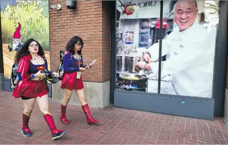  ?? RICHARD VOGEL/THE ASSOCIATED PRESS ?? Women dressed as Supergirl walk along a downtown San Diego street during 2018 Comic-Con.