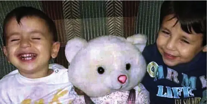  ??  ?? Young lives cut short: Smiling and cuddling a teddy bear, brothers Aylan and Galip Kurdi, whose bodies were washed up on a beach in Turkey after their dinghy capsized