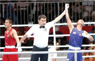  ?? PSC PHOTO ?? NAPASIGAW sa labis na kasiyahan si Rogen Ladon ng Philippine­s nang itaas ng referee ang kanyang kamay hudyat ng pananaig kontra kay Yuttapong Tongdee ng Thailand sa semifinals ng men’s flyweight class ng boxing competitio­n sa 18th Asian Games sa Jakarta Internatio­nal Expo.