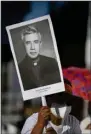  ?? (AP/Salvador Melendez) ?? A woman carries a poster depicting the Rev. Rutilio Grand, during his beatificat­ion ceremony Saturday in San Salvador, El Salvador.