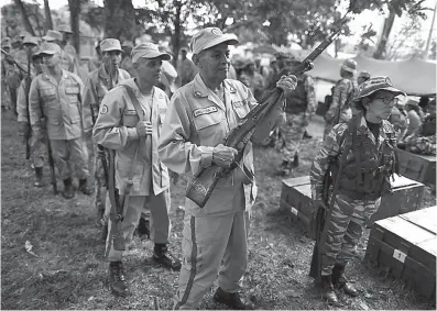  ?? Associated Press ?? n Militia members line up on Friday to return rifles after taking part in a military drill in Fort Tiuna, Caracas, Venezuela.