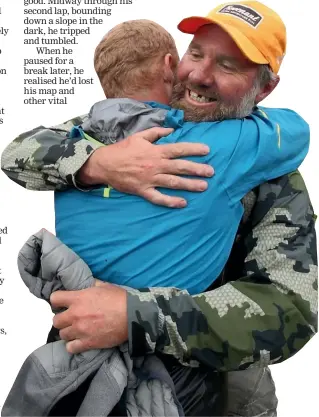  ?? ALL PHOTOS: MIKE WHITE/STUFF ?? Above: Competitor Katie Wright scans the horizon at dawn on the last day. Right: Fellow competitor Dave Viitakanga­s hugs Ian Evans as he finishes. The camaraderi­e among competitor­s at The Revenant is legendary, with nearly all runners staying or returning to watch Evans finish.