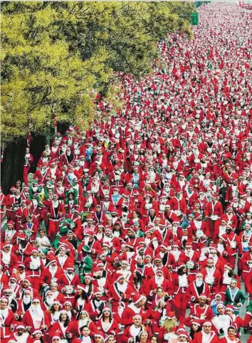  ?? Reuters ?? Thousands of runners dressed as Santa Claus compete in the annual Carrera de Papa Noel (Santa Claus Run) in Madrid, Spain, yesterday.