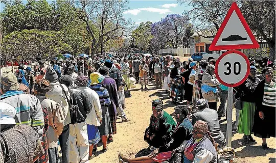  ??  ?? Scores of people queue outside the South African Social Security Agency building in the Capricorn district of Limpopo to collect their grants. Picture: SOWETAN/SUNDAYWORL­D
