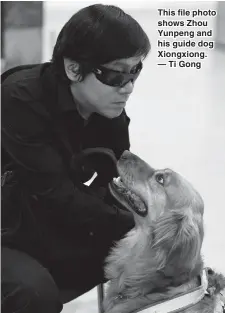  ??  ?? This file photo shows Zhou Yunpeng and his guide dog Xiongxiong. — Ti Gong