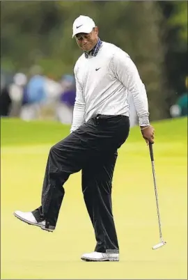  ?? David J. Phillip Associated Press ?? TIGER WOODS grimaces after missing a birdie putt on the eighth green. Woods had four three-putts and a four-putt, his first career four-putt at a Masters.