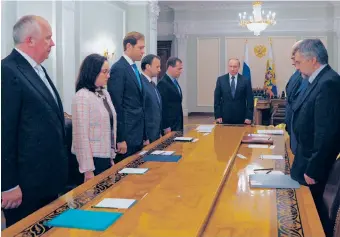  ?? | RIA-NOVOSTI, ALEXEI DRUZHININ, PRESIDENTI­AL PRESS SERVICE/AP ?? Russian President Vladimir Putin (center) and members of his government on Thursday observe a moment of silence mourning the victims killed in the Malaysia Airlines plane crash.