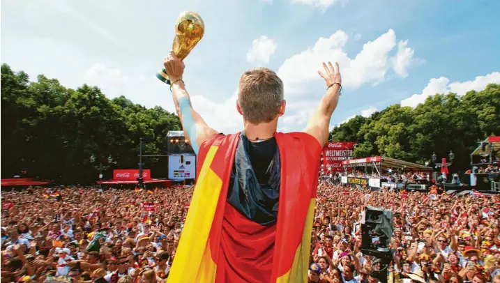  ?? Foto: Alex Grimm/Bongarts/Getty Images/DFB, dpa ?? Sportliche­s Glück: Nach dem Gewinn des Weltmeiste­rtitels 2014 vor den Fans in Berlin.