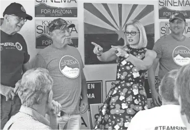  ?? BOB CHRISTIE/AP ?? Democratic U.S. Senate candidate Kyrsten Sinema talks to volunteers Thursday at a get-out-the-vote phone bank in Phoenix, alongside members of the “Veterans for Sinema” group. Sinema and Republican Martha McSally are taking different approaches to the campaign, with Sinema focusing on retail politics and McSally rallying with high profile Republican­s such as Donald Trump Jr.