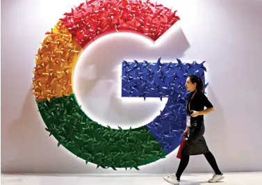  ?? AP Photo/Ng Han Guan ?? ■ A woman walks past the Google logo at the China Internatio­nal Import Expo on Nov. 5, 2018, in Shanghai. Chinese tech giant Huawei is racing to develop replacemen­ts for Google apps, since U.S. sanctions imposed on security grounds block Huawei from using YouTube and other popular Google “core apps.”