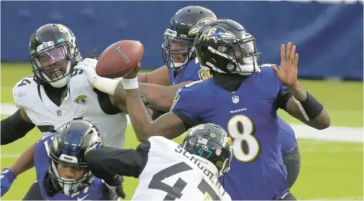  ?? KARL MERTON FERRON/BALTIMORE SUN ?? Jaguars defensive end Dawuane Smoot, left, tries to pressure Ravens quarterbac­k Lamar Jackson during a 2020 game at M&T Bank Stadium. Smoot leads Jacksonvil­le this season with six sacks on his 21 pressures.