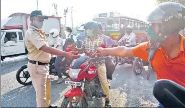  ?? SATISH BATE/HT PHOTO ?? A policeman checks identity cards of those stepping out amid the curfew, at Airoli toll naka on Tuesday.